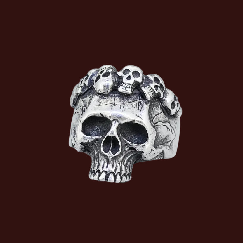 Silver skull ring with small skulls on a light background