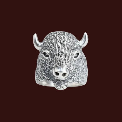 Silver bull head ring on a light gray background